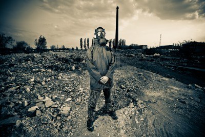9642119-bizarre-portrait-of-man-in-gas-mask-on-smoky-industrial-background-with-pipes-after-nuclear-disaster
