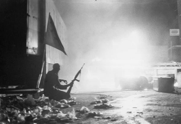 Joe McCann fotografato durante i “Troubles” dell’estate 1971. Accanto a lui la “starry plough flag”, la bandiera dell’Irish Citizen Army, il movimento repubblicano e socialista fondato da James Connolly.
