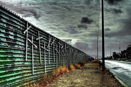 Cruces de palo‎  L’immagine si riferisce alle croci di legno che da qualche tempo vengono apposte a centinaia sul ‎muro che marca la frontiera tra Messico e USA, a ricordo dei migranti morti nel tentativo di ‎lasciarsi alle spalle la miseria.‎