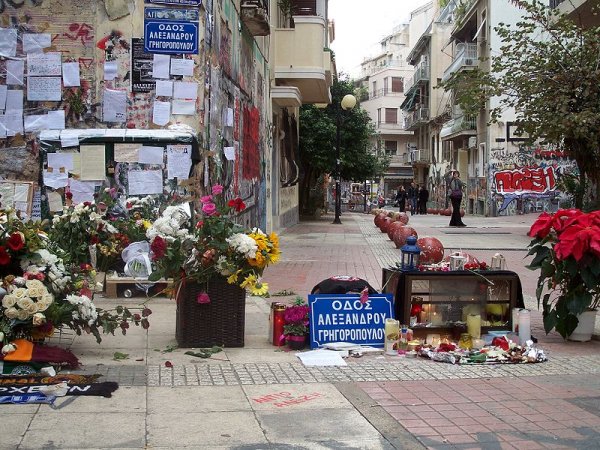 Via Tzavellas, nel quartiere di Exarchia, Atene: il luogo dove è stato ucciso Alexis Grigoropoulos. Si notino, come in Piazza Alimonda trasformata in Piazza Carlo Giuliani, i cartelli stradali che dicono Via Alexandros Grigoropoulos.