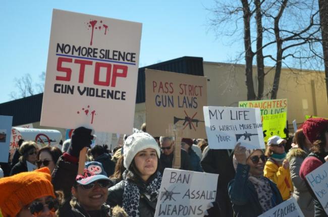 A woman in a crowd holds up a sign protesting gun violence at a march in Morristown, New Jersey. 