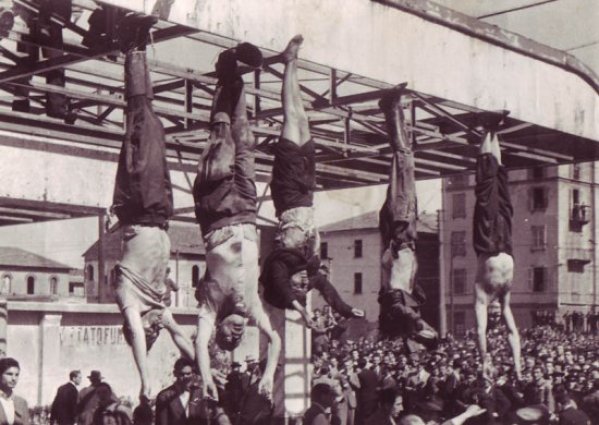 Piazzale Loreto, 29 aprile 1945. I corpi di (da sinistra) Bombacci, Mussolini, Petacci, Pavolini, Starace. La pompa di benzina dove furono appesi i corpi non esiste più.