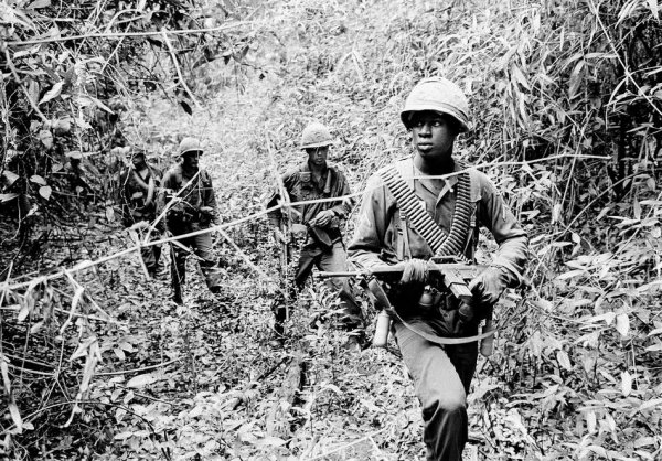 The sun breaks through the dense jungle foliage around the embattled town of Binh Gia, 40 miles east of Saigon, in early January 1965, as South Vietnamese troops, joined by U.S. advisors, rest after a cold, damp and tense night of waiting in an ambush position for a Viet Cong attack that didn't come. One hour later, as the possibility of an overnight attack by the Viet Cong diasappeared, the troops moved out for another long, hot day hunting the elusive communist guerrillas in the jungles. (AP Photo/Horst Faas)