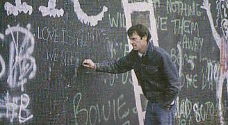 Neil scrive "Love is all we need" sul muro di Berlino, 1982