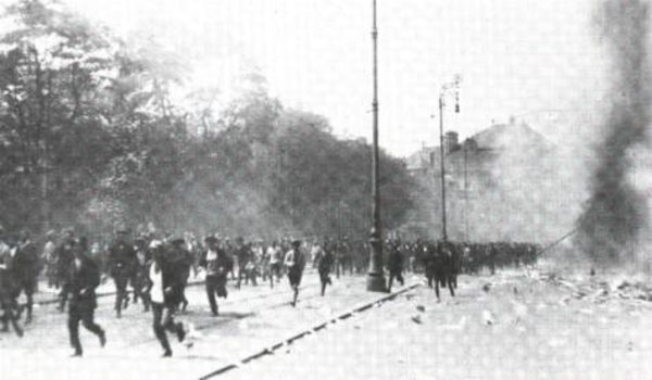 La carneficina: La polizia spara sulla folla che scappa. Sullo sfondo, il Palazzo di Giustizia in fiamme.