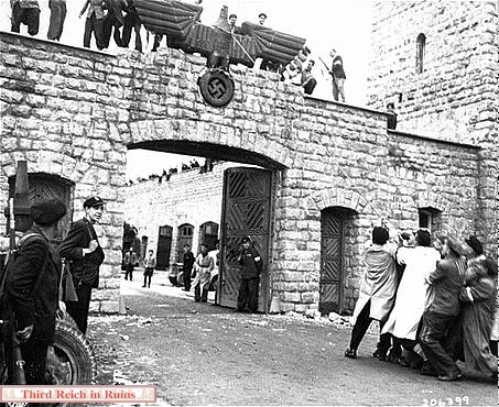 Gli ormai ex prigionieri distruggono i simboli nazisti a Mauthausen