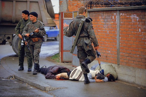 <br />
‎Bosnia 1992. Paramilitari ‎serbi infieriscono sui corpi di civili musulmani uccisi, foto di Ron ‎Haviv dalla serie “Blood & Honey: a Balkan War Journal”.‎