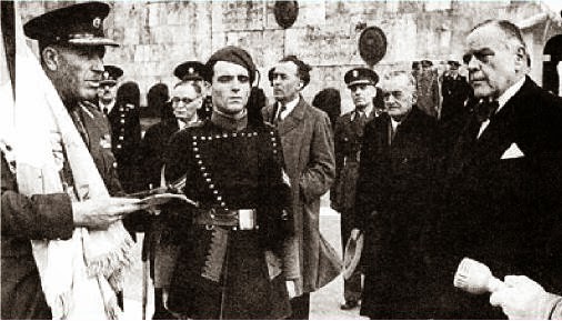 Atene, 12 marzo 1944. Celebrazione della "Giornata dell'eroe tedesco". A sinista, un qualche gerarca collaborazionista; al centro un Tagmastasfalitis in alta uniforme e, a destra, il primo ministro fantoccio Ioannis Rallis.